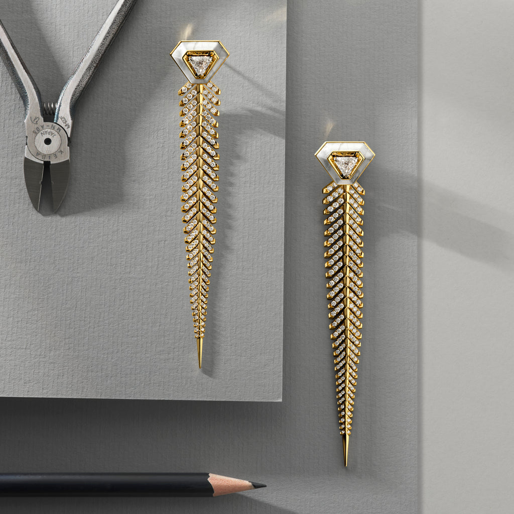 Gold earrings with intricate design on a gray background