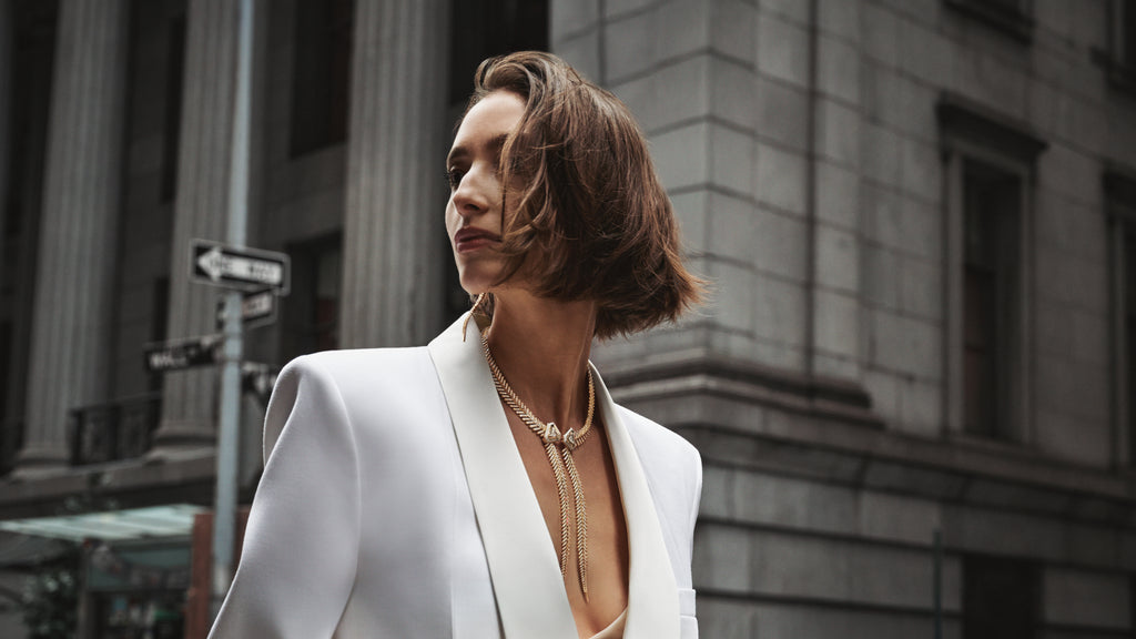 Woman in a white blazer standing in an urban setting