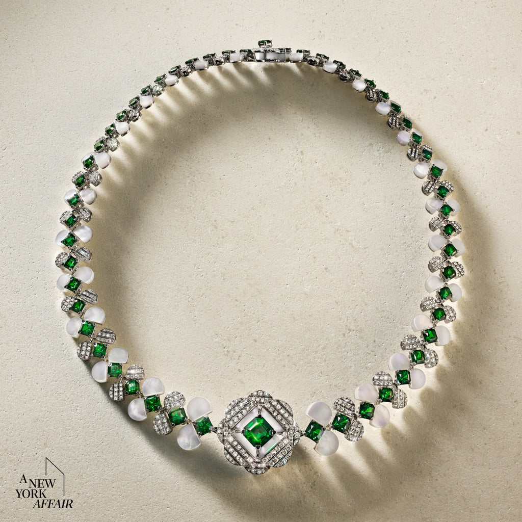 Elegant necklace with emeralds and pearls on a beige background