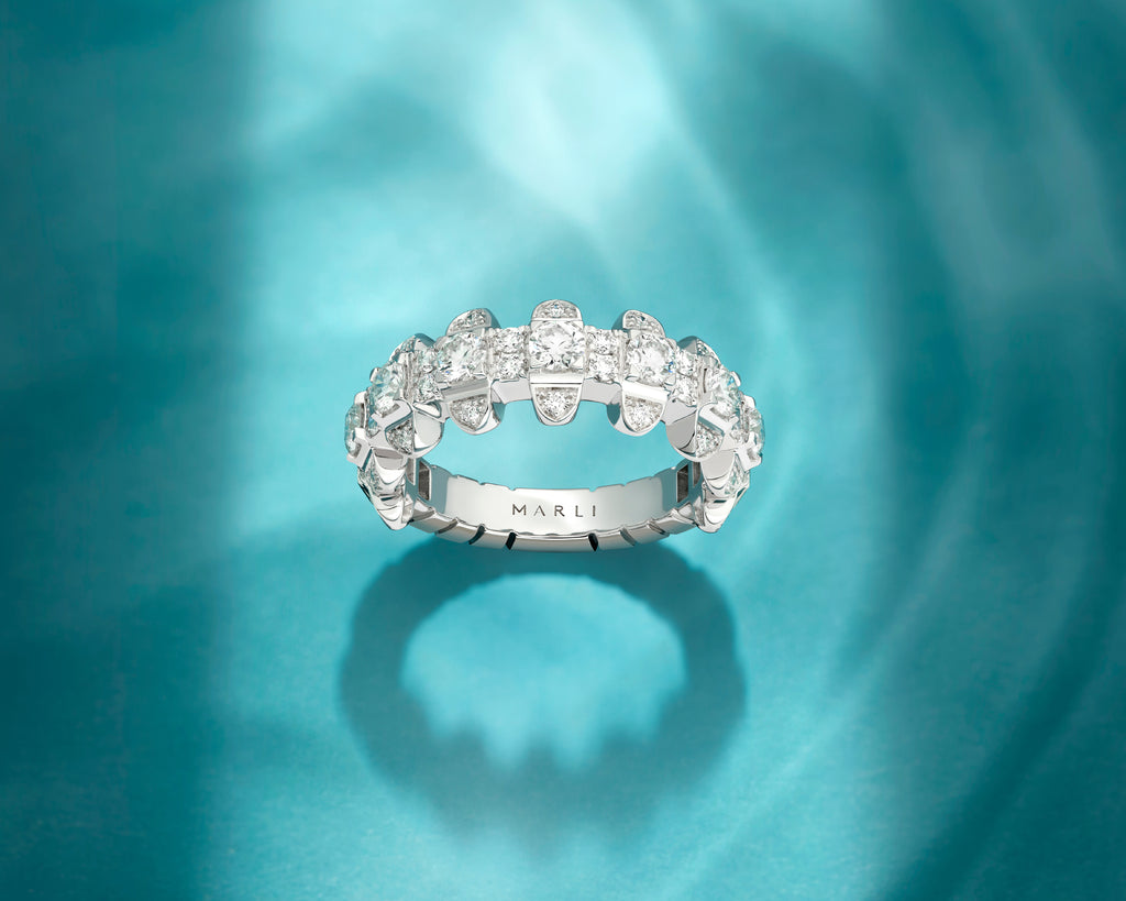 Silver ring with floral design on a teal background