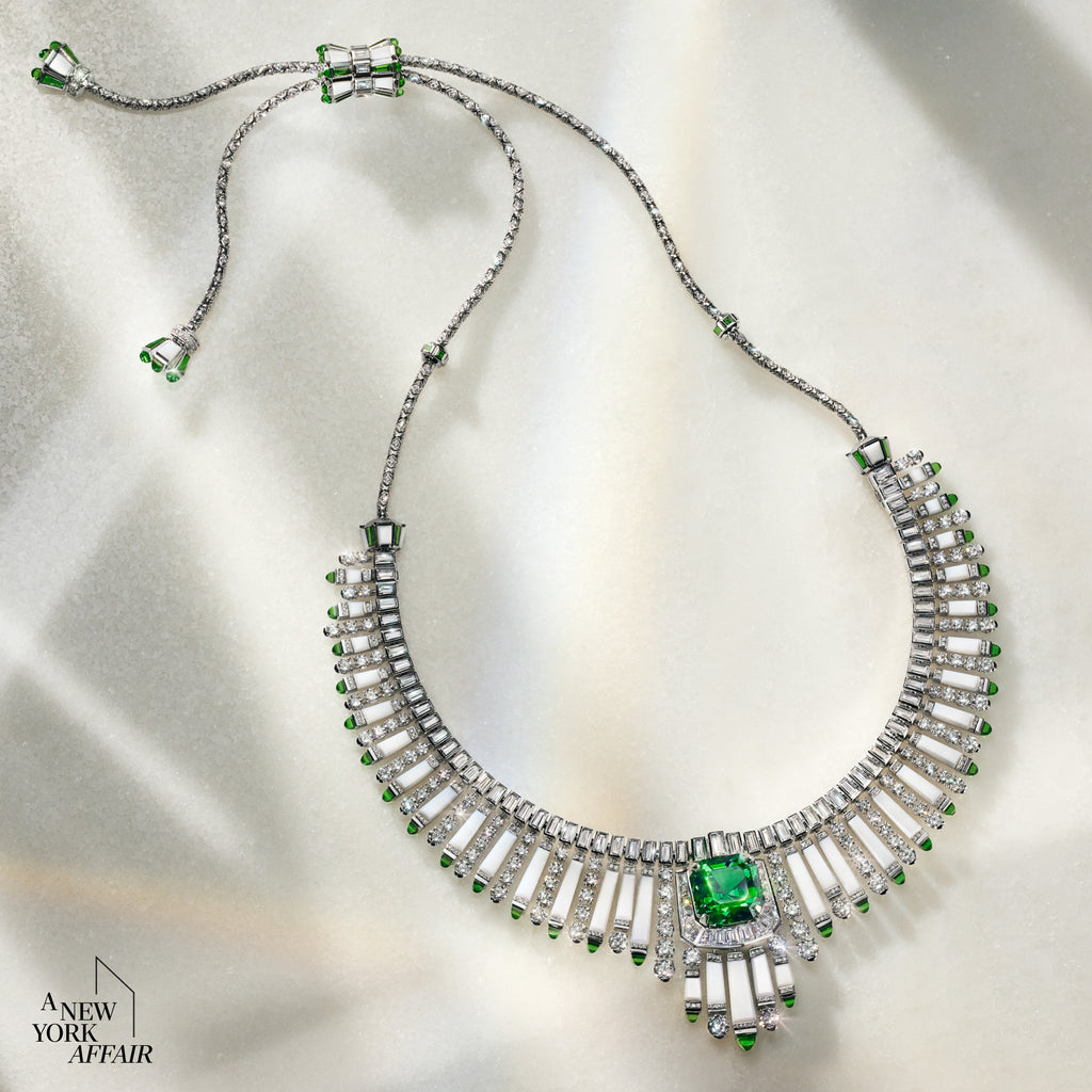 Elegant necklace with green gemstones on a soft fabric background