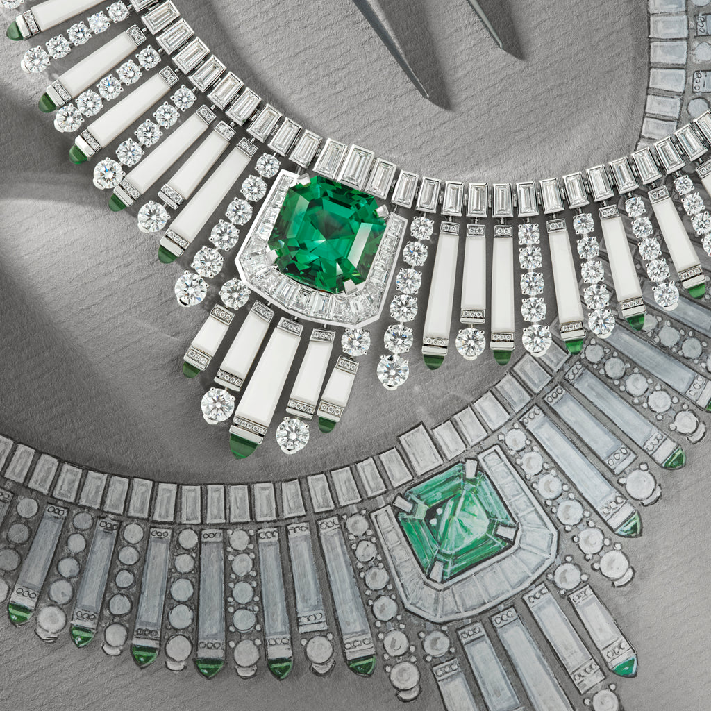 Close-up of a diamond and emerald necklace on a gray background
