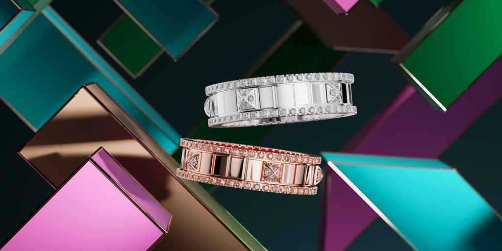 One white gold ring and one rose gold, floating in front of metallic blocks in teal, pink, green and gold.
