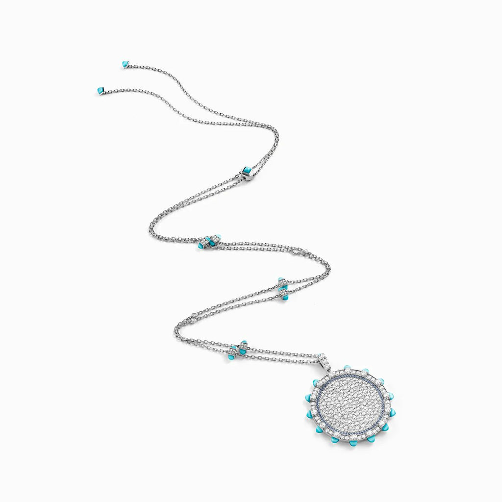 Silver necklace with a round pendant featuring turquoise stones on a white background
